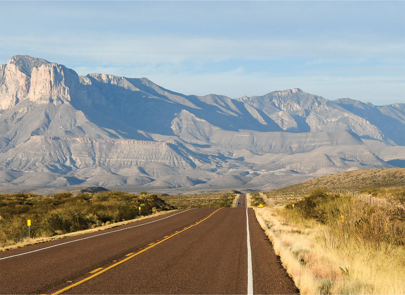 An open highway winding through mountains in the high desert