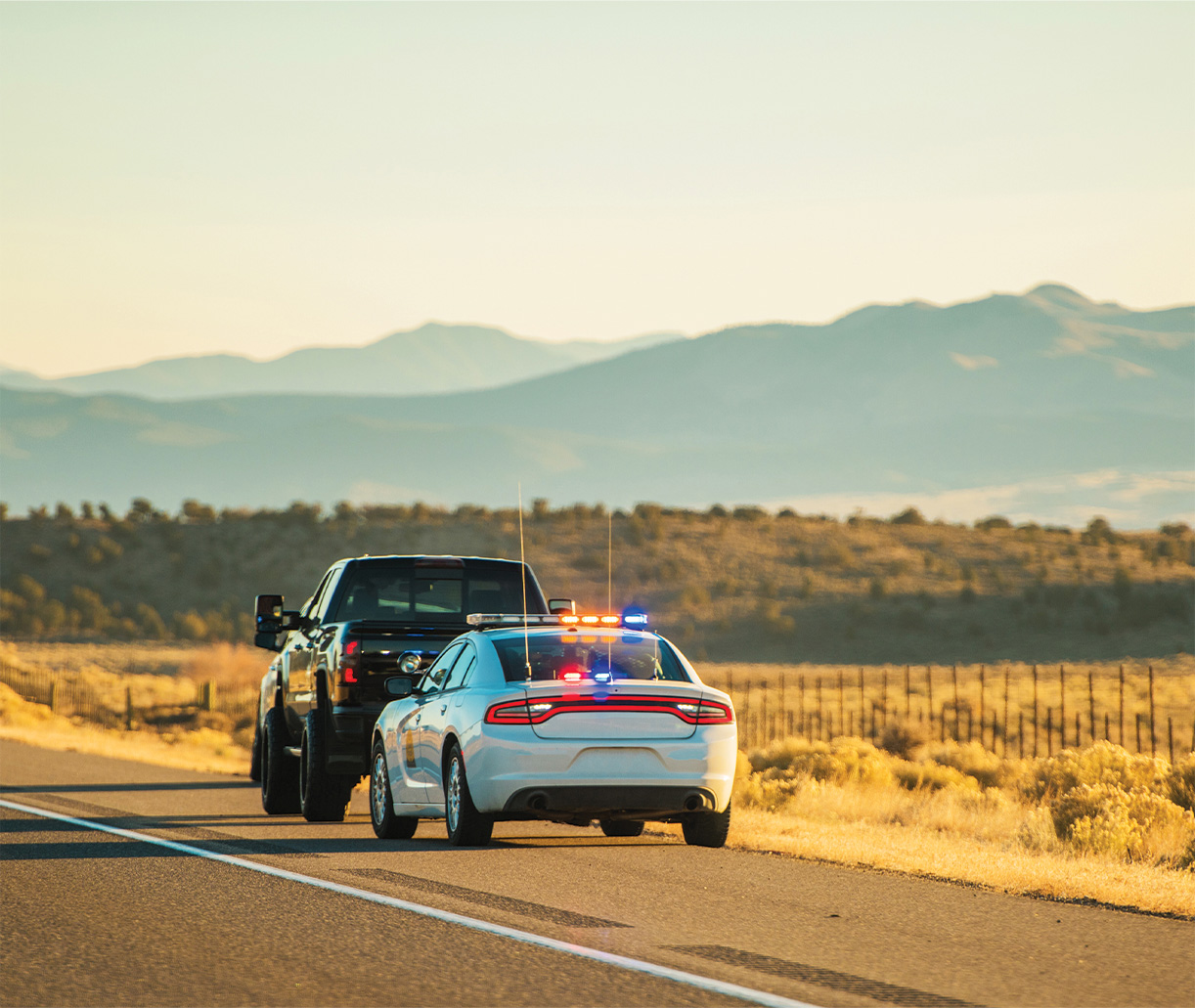 A police cruiser conducting a traffic stop on a rural highway