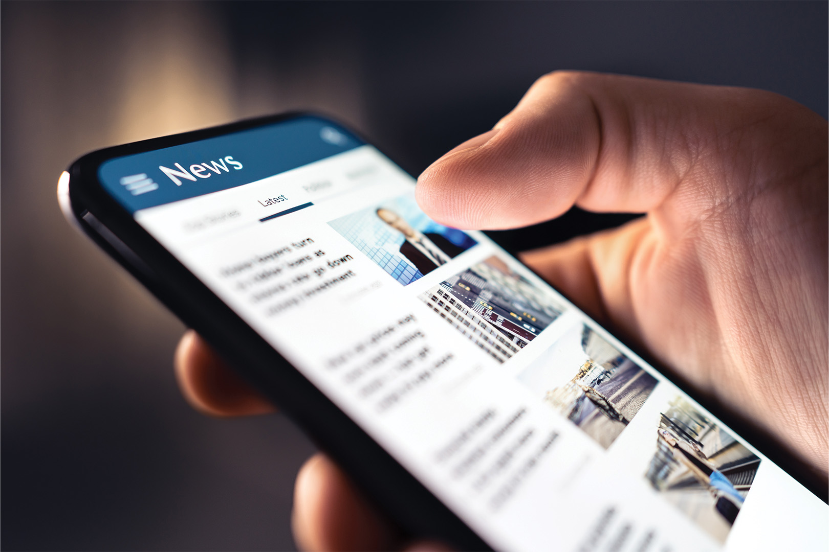 A close-up of a hand holding a smartphone showing a news app